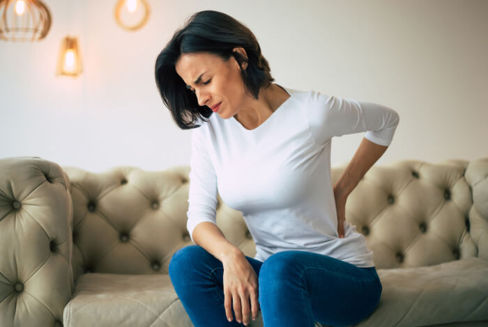 woman sitting on a couch with back pain