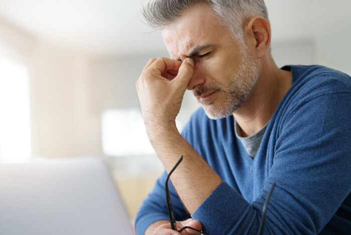 man sitting at desk with a headache