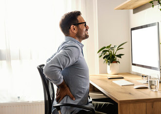 man sitting on a couch with low back pain