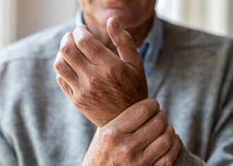 older-man-holding-painful-wrist-sq
