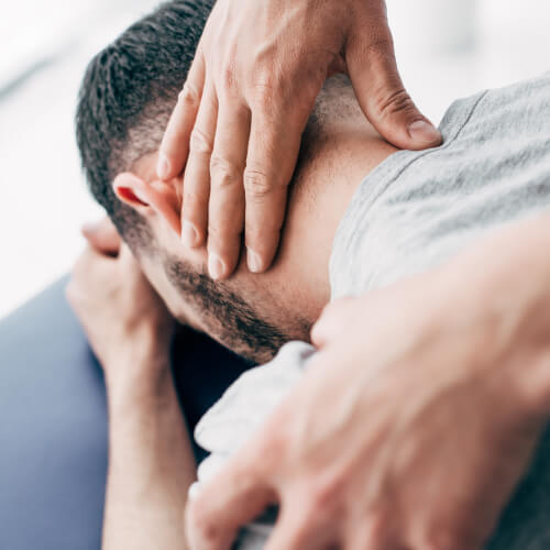 Male patient getting his neck adjusted by a chiropractor