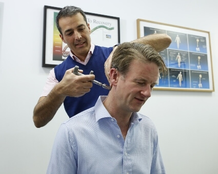 Chiropractor using Activator method to treat patient