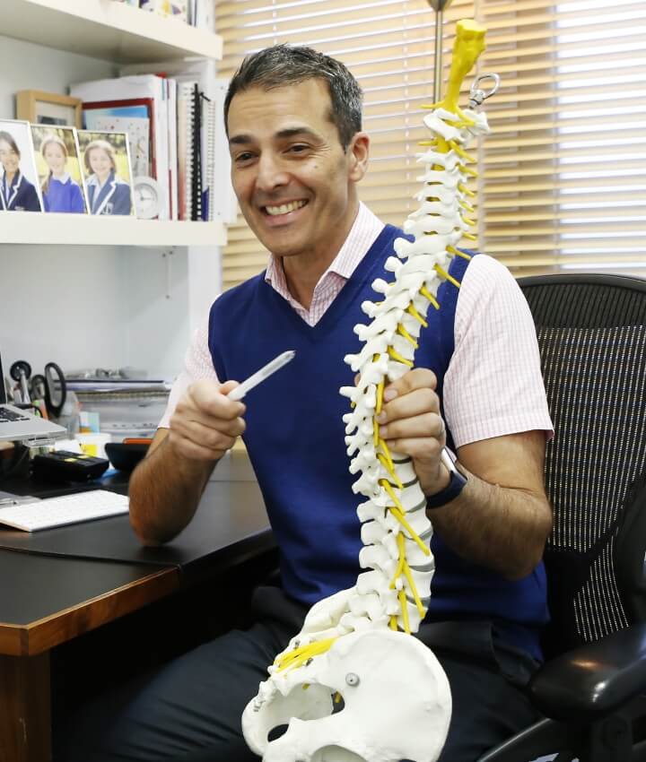 East Horsley chiropractor pointing at a spine model
