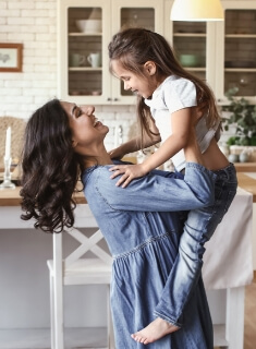 Mother lifting her young daughter in the air