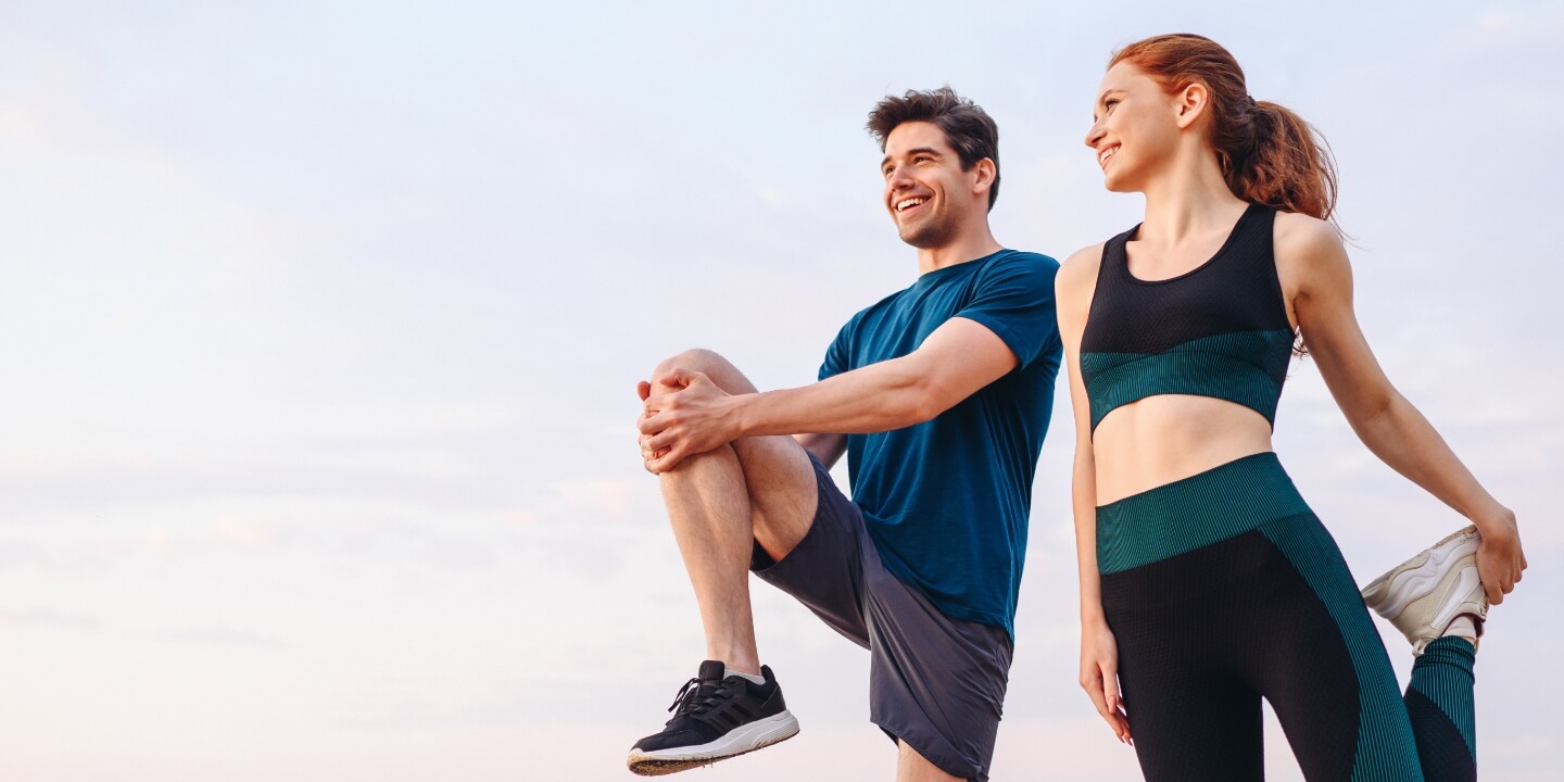 Male and female athletes doing some stretches