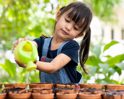 Little girl watering plants