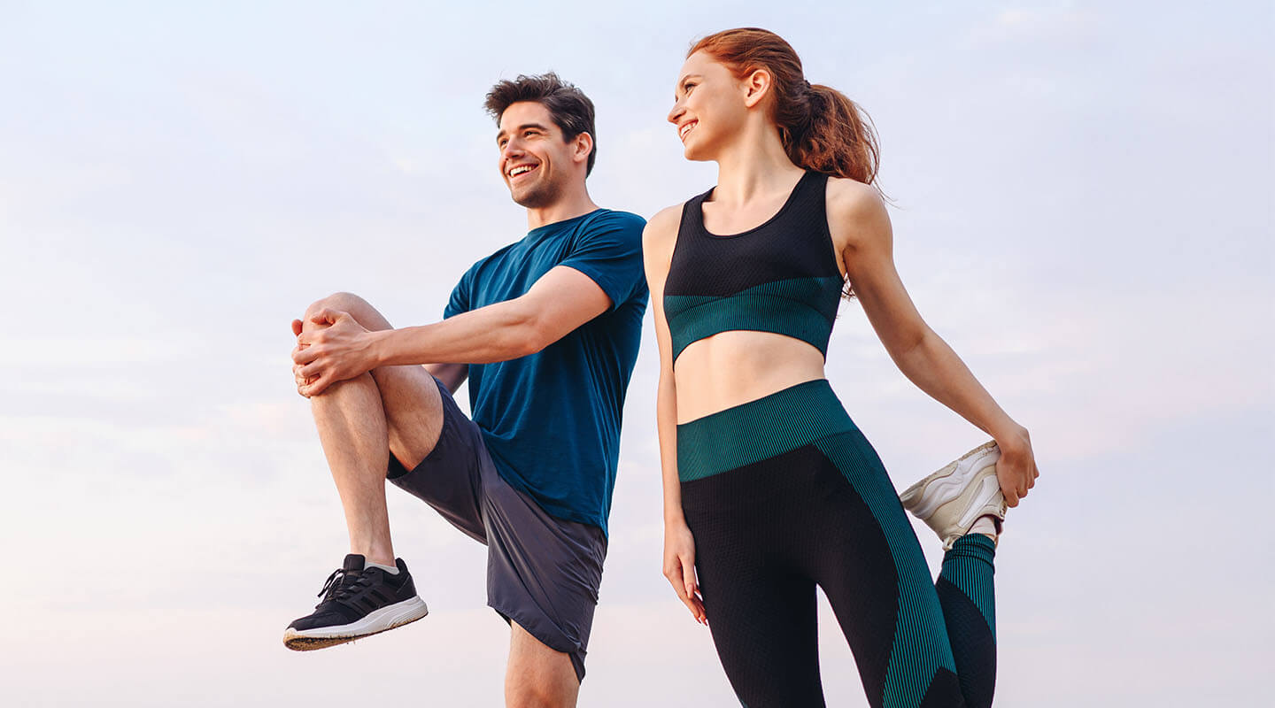 Male and female athletes doing some stretches