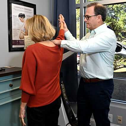 Chiropractor using physiotherapy to treat patient