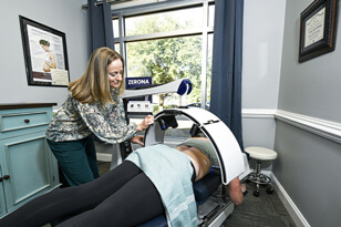 Chiropractor assisting patient with Zerona Laser Therapy