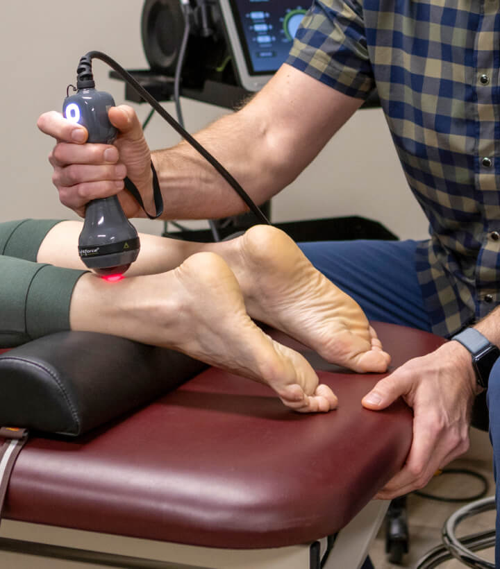 Sturgis chiropractor Dr Gunderson using laser tool on patients leg