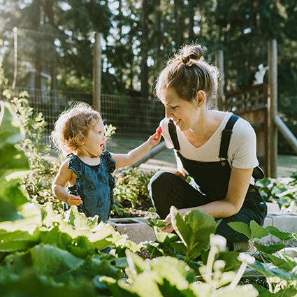 mom and kid gardening outdoors together
