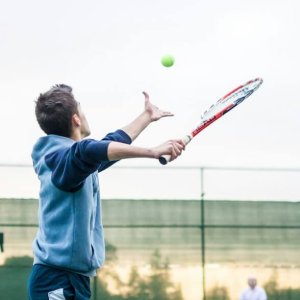 four men playing double tennis during daytime
