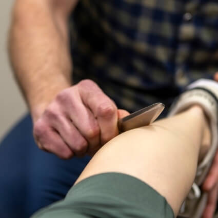 soft tissue therapy tool on patients leg