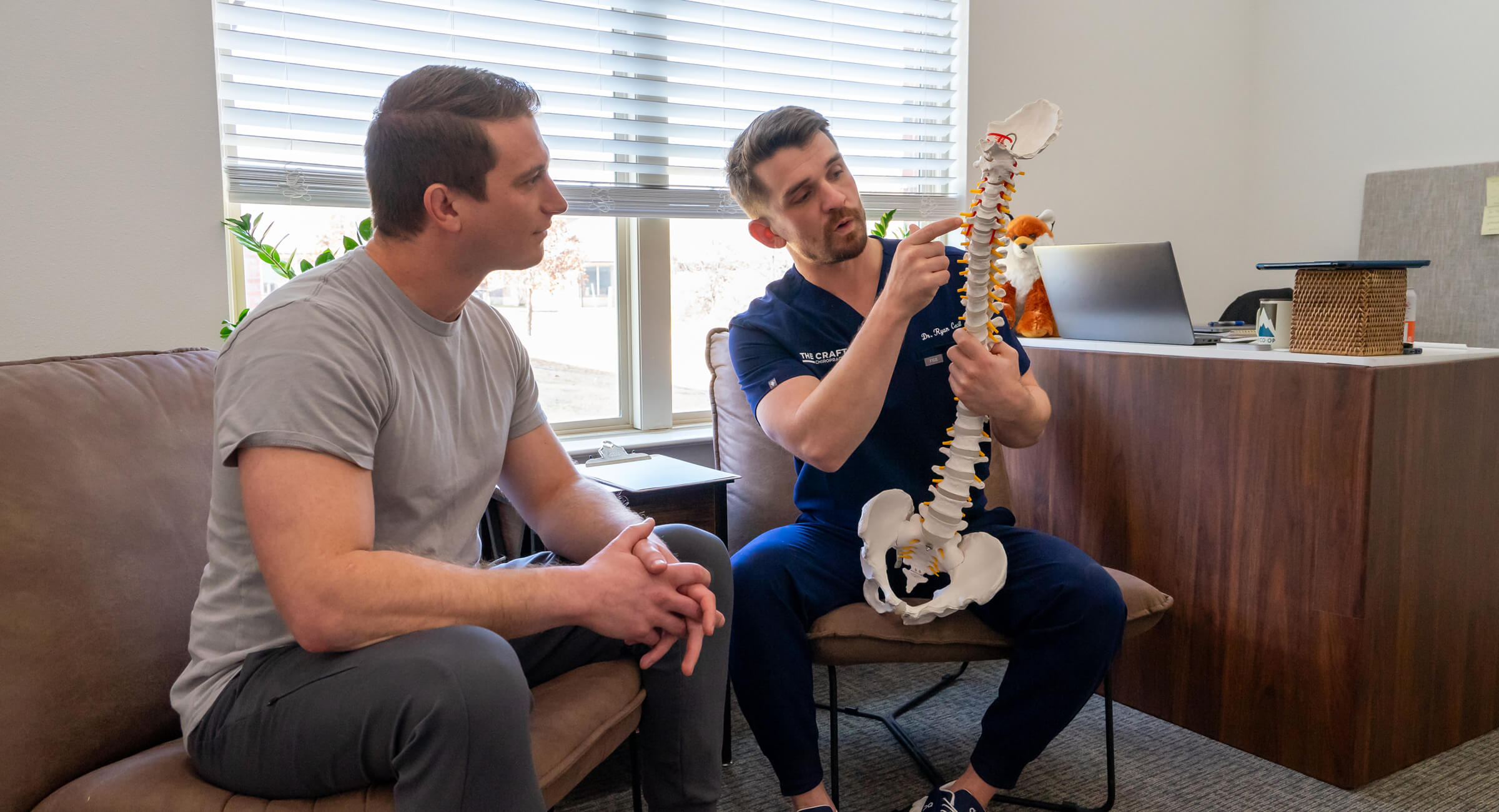 Frisco Chiropractor Dr. Ryan pointing at spine model