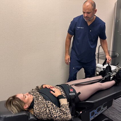 Dr. Paige talking to patient on table