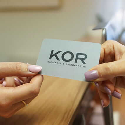 Close-up view of KOR Wellness & Chiropractic business card