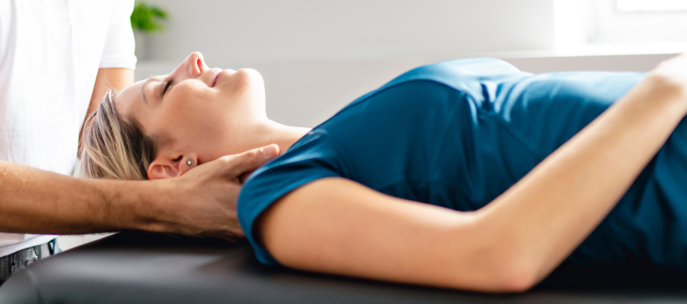Smiling woman receiving a chiropractic neck adjustment
