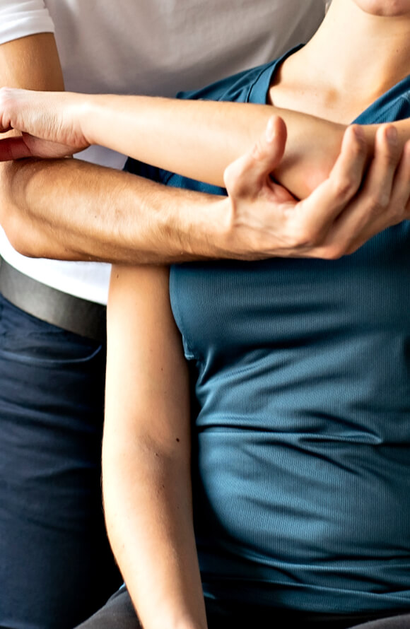 Physiotherapist stretching a patient's arm