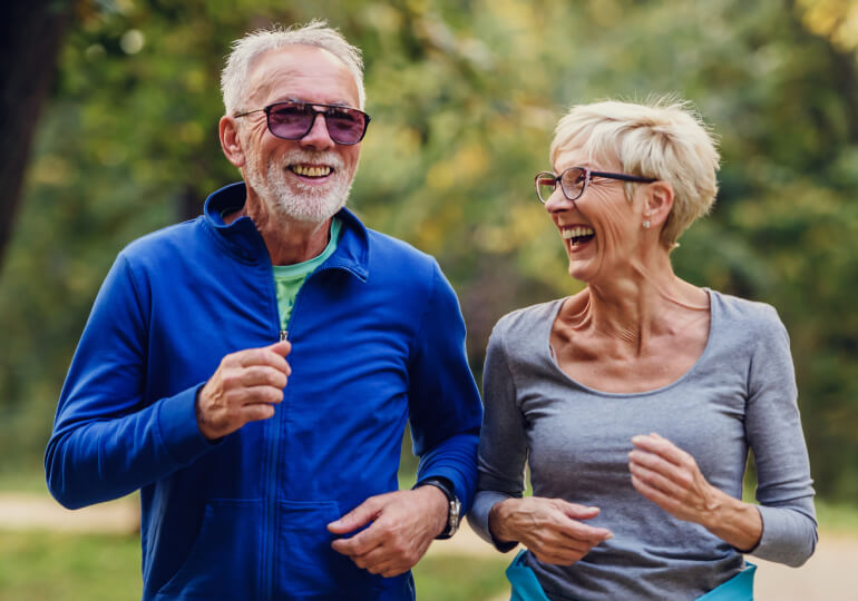 Smiling elderly couple out jogging
