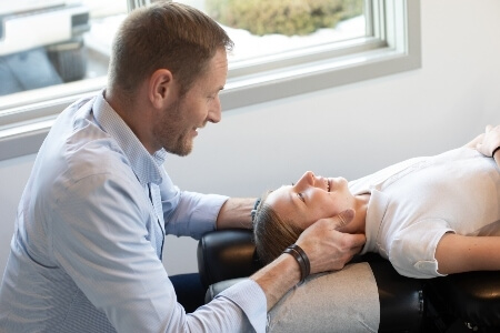 Chiropractor adjusting a young female patient