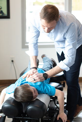 Pediatric patient receiving an upper-back adjustment