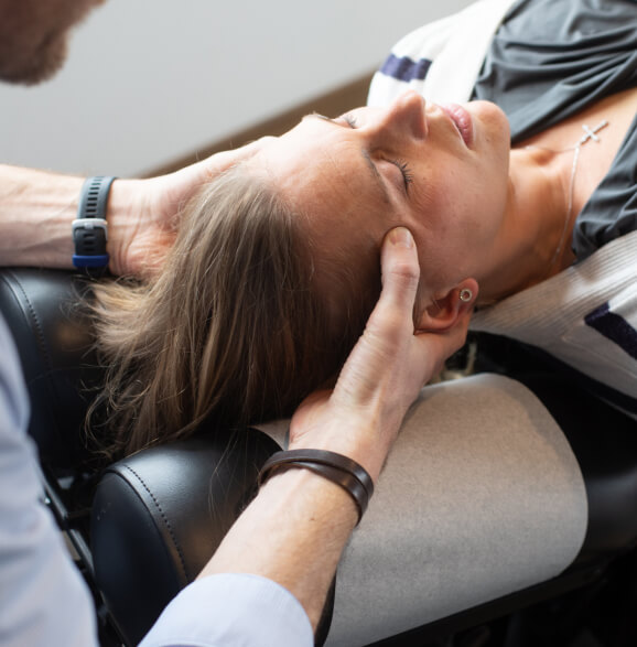 Burlington chiropractor adjusting a female patient's neck