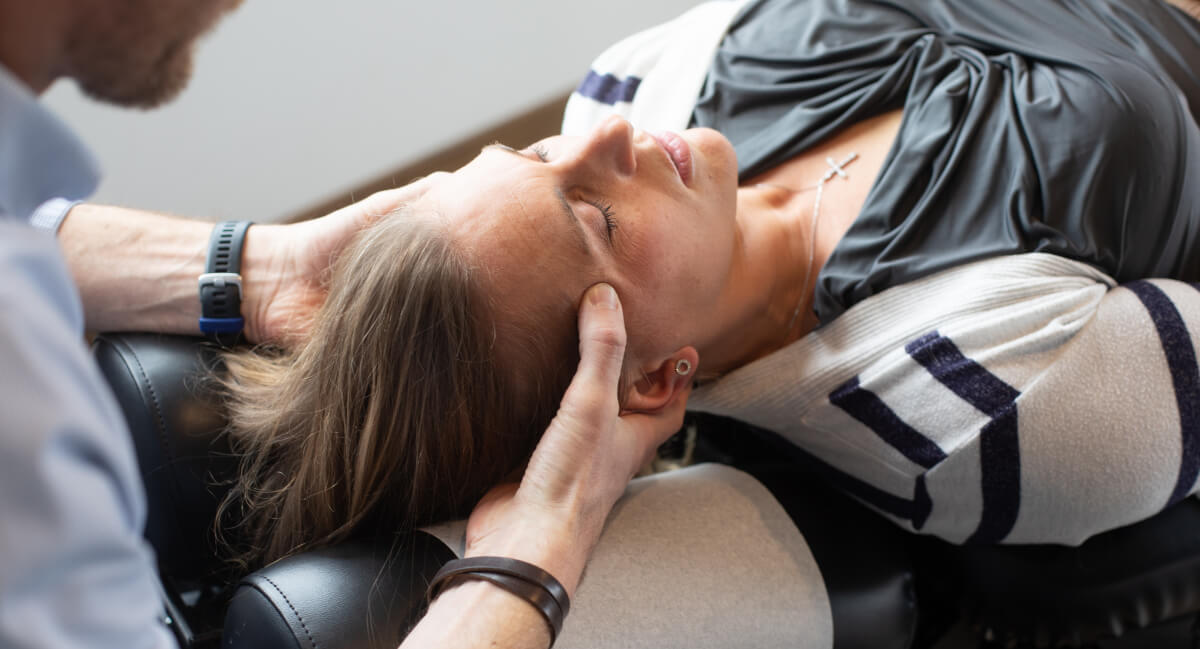 Burlington chiropractor adjusting a female patient's neck