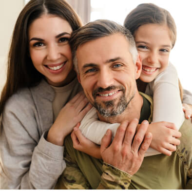family of 3 smiling and hugging