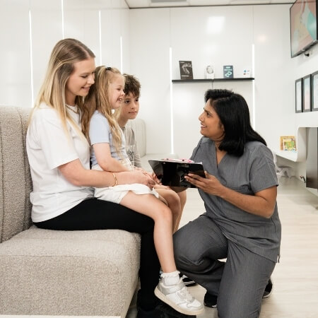Dentist talking to a patient and her kids