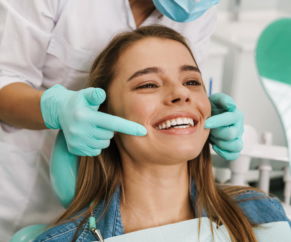 Dentist touching the sides of a patient's mouth 