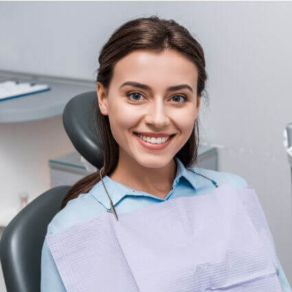 woman smiling in dental chair with white teeth