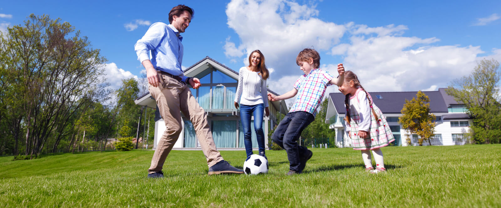 Family of four playing soccer outdoors