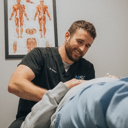 Hendersonville chiropractor Dr Dotson adjusting patient while smiling