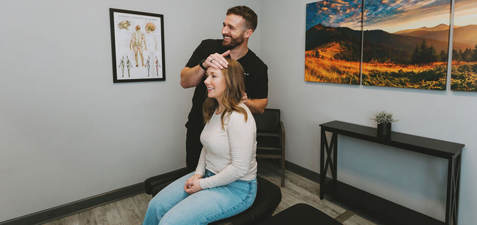 Hendersonville chiropractor Dr. Garrin Dotson adjusting patients neck