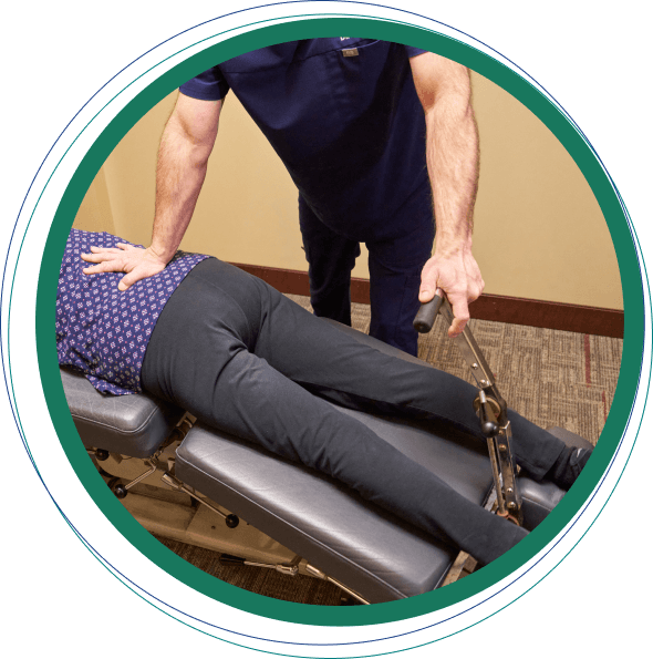 Muskego chiropractor adjusting a female patient's back