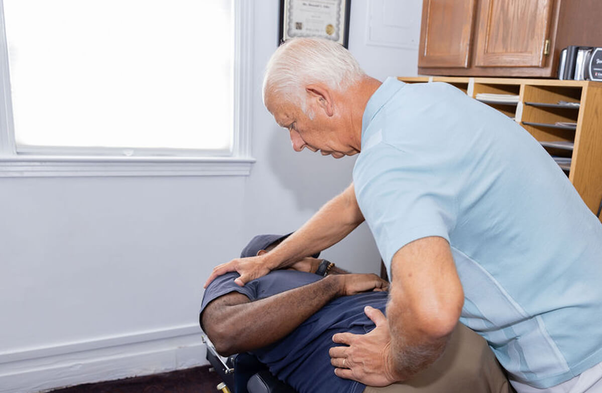 Mobile chiropractor adjusting a male patient