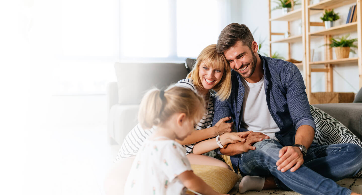 Parents smiling at their young daughter