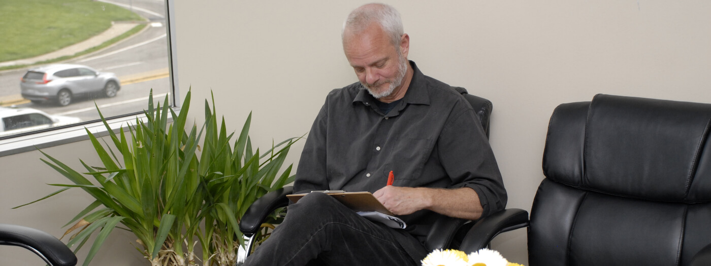 Patient filling in paperwork in waiting room