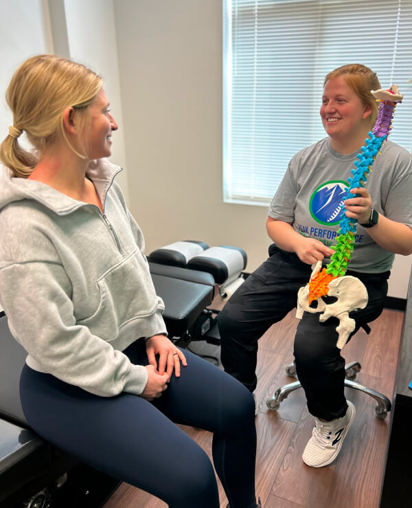 Chiropractor showing spine model to patient