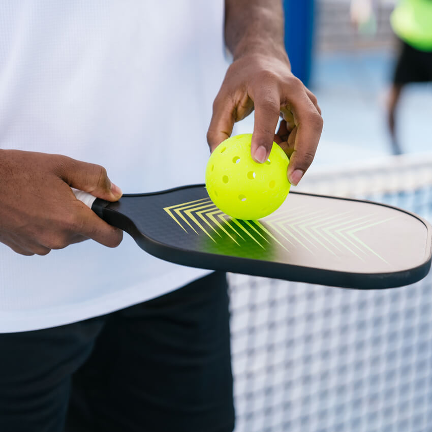 Holding pickleball paddle and ball