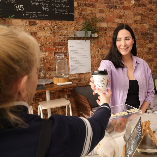 Receptionist handing coffee to patient