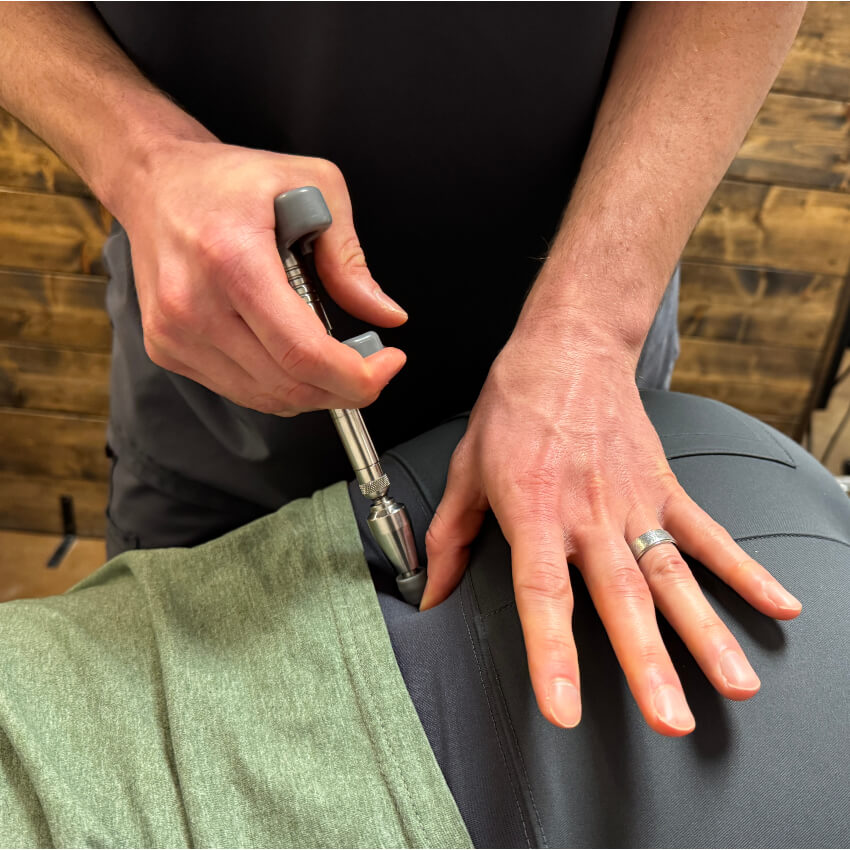 patient having back adjusted with tool