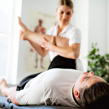 female practitioner adjusting man in black shorts leg