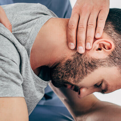 man in grey shirt getting neck adjustment