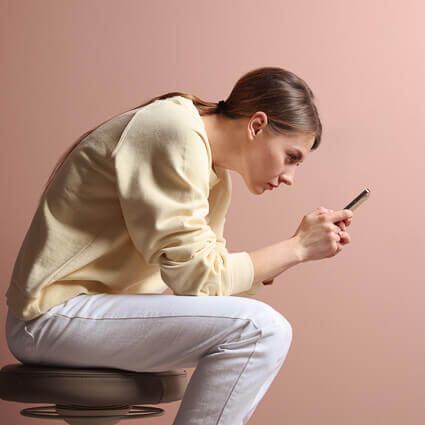 teen looking at phone with bad posture