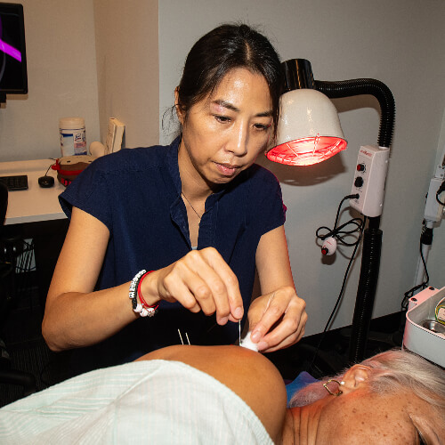 Acupuncture applied to patient's shoulder