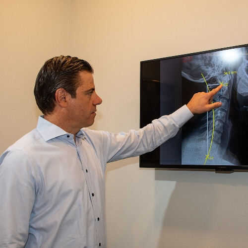 Chiropractor pointing at x-rays