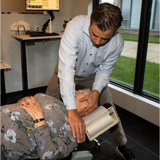 Chiropractor adjusting a female patient's neck