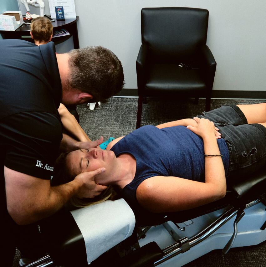 chiropractor adjusting patients neck