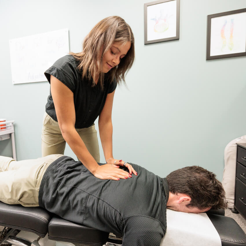 chiropractor adjusting patients back